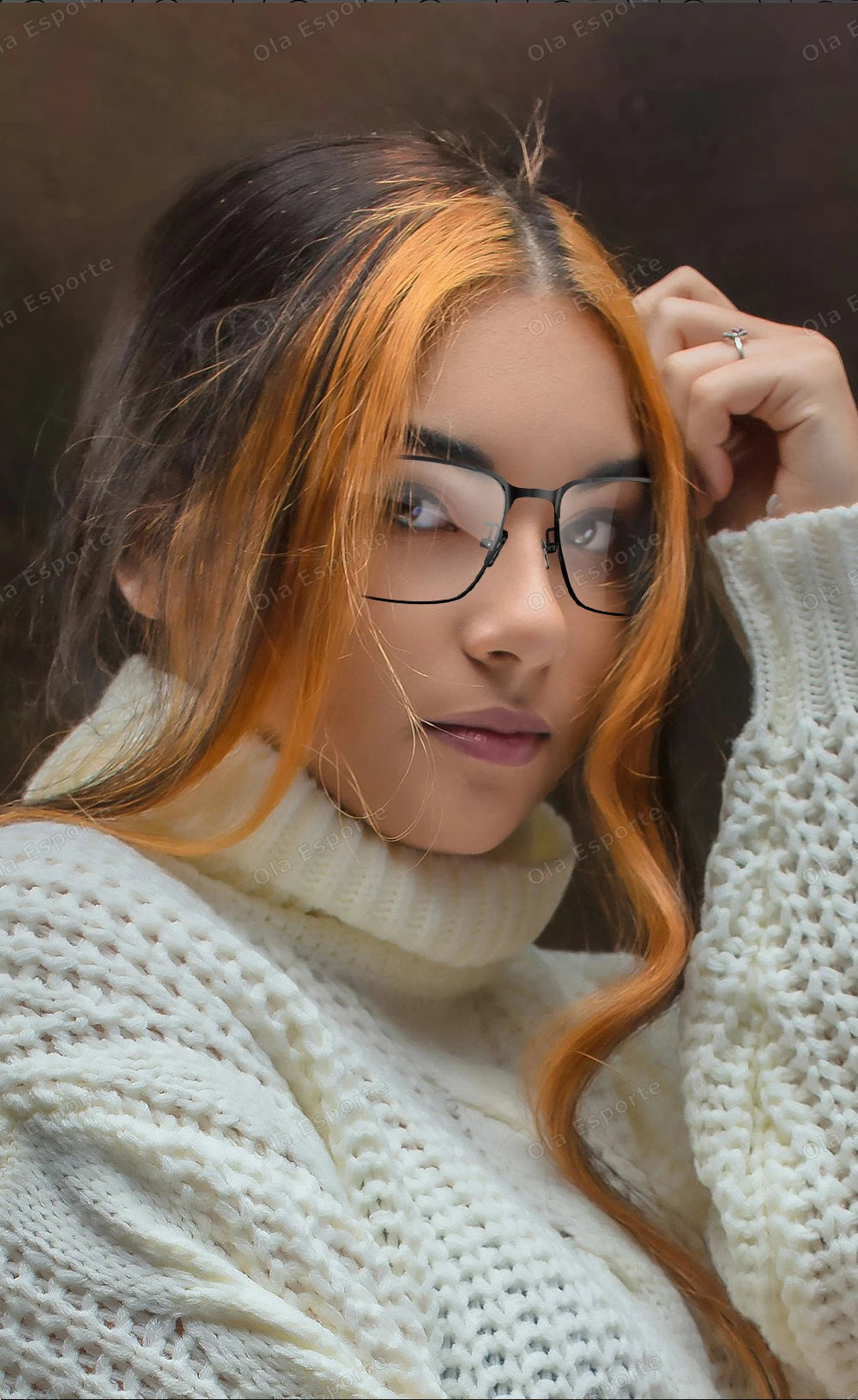 Woman with orange hair and glasses wearing a white sweater.