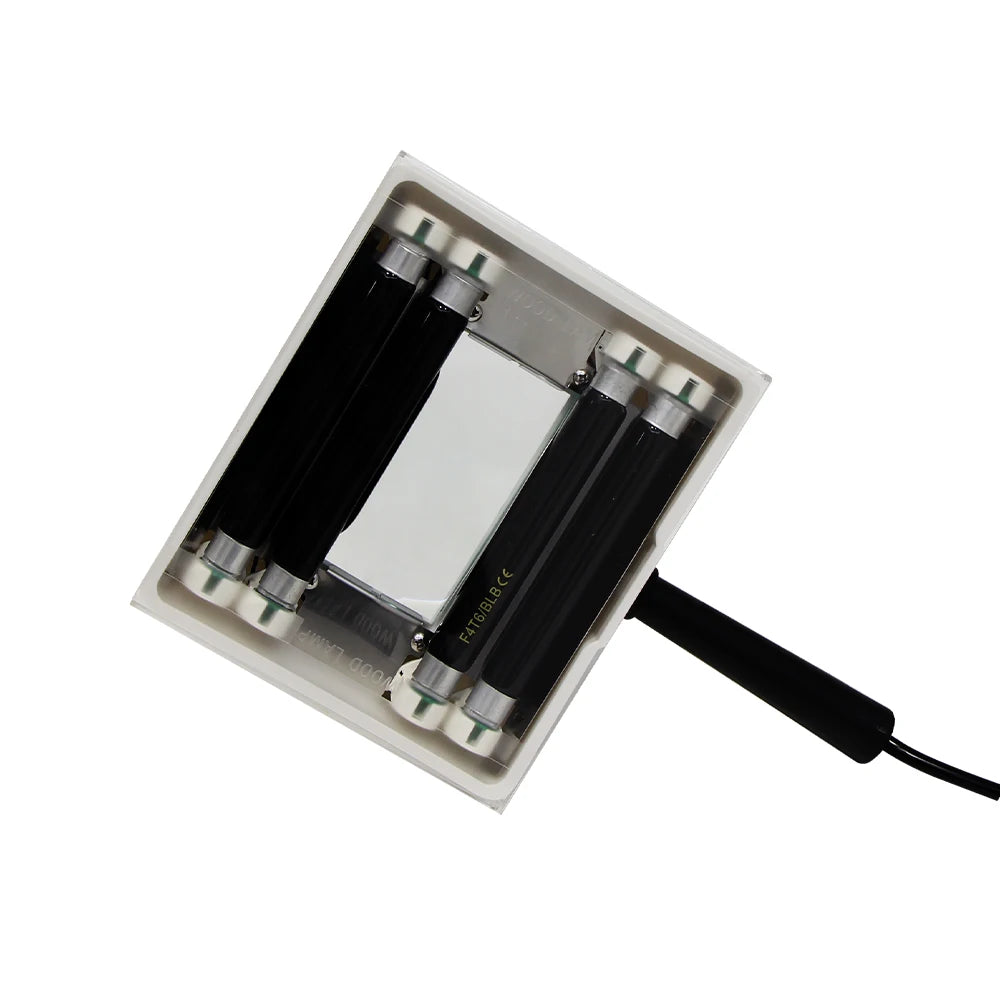 Rectangular metal component with cylindrical elements and a cable on a white background