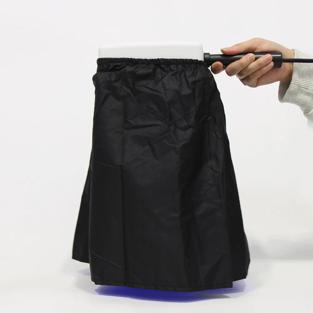 Black skirt being adjusted with a rod on a white background