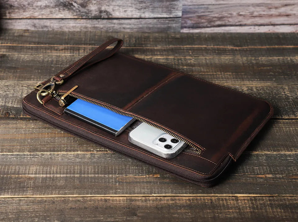 Brown leather wallet with phone and key on a wooden surface