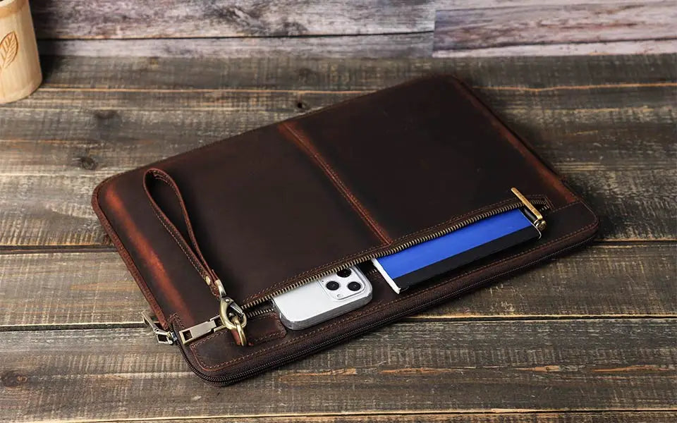 Brown leather wallet with a zipper on a wooden surface