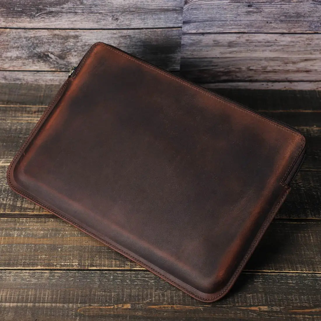 Brown leather sleeve on a wooden surface