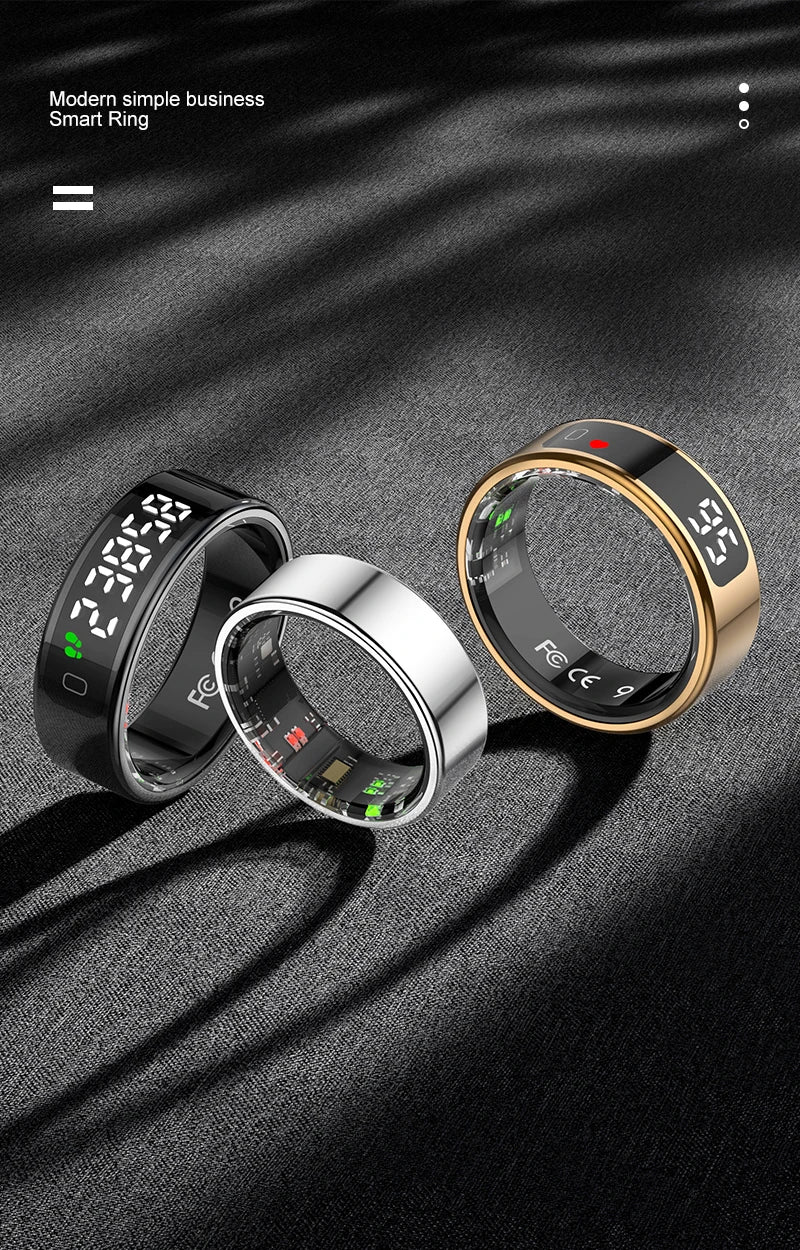 Three smart rings in black, silver, and gold on a dark fabric background
