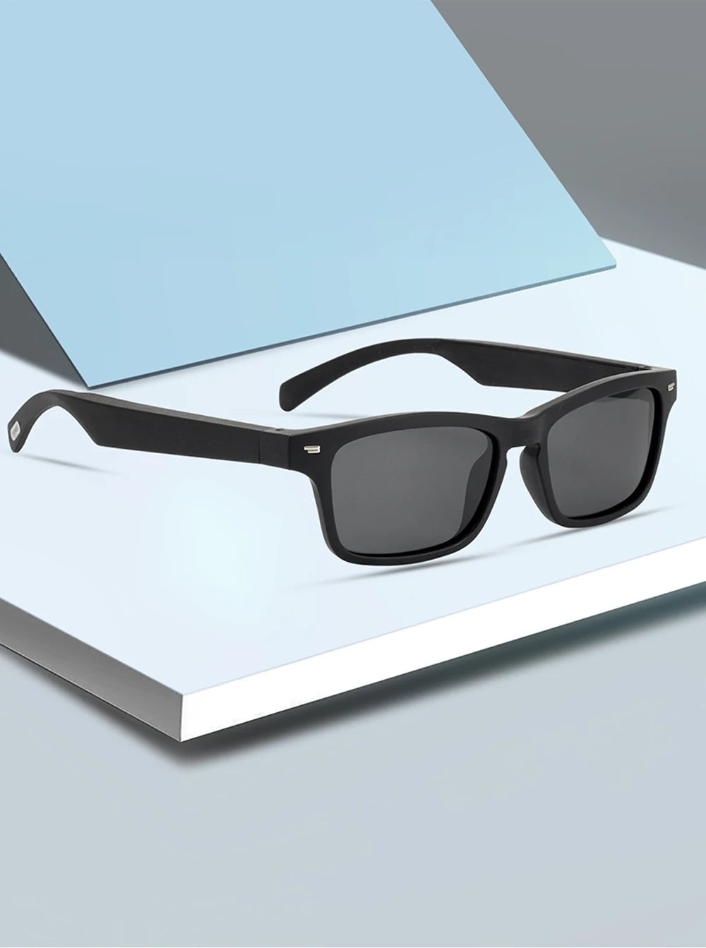 Black sunglasses on a white surface with a blue light filter